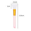 A pink silicone facial mask brush with a white tip and gold handle shown next to dimension lines.