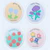 A pack of four natural cotton cleaning sponges with floral designs on a white background.