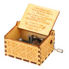 A vintage engraved wooden music box with a lid open showing an engraved message inside.