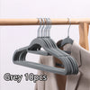 Grey velvet slim hangers set with 10 pieces hanging on a wooden rod