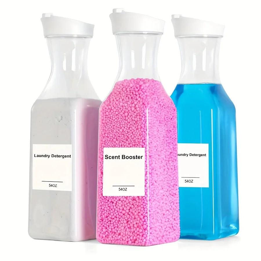 Three clear glass dispensers containing liquid laundry detergent and pink scent booster