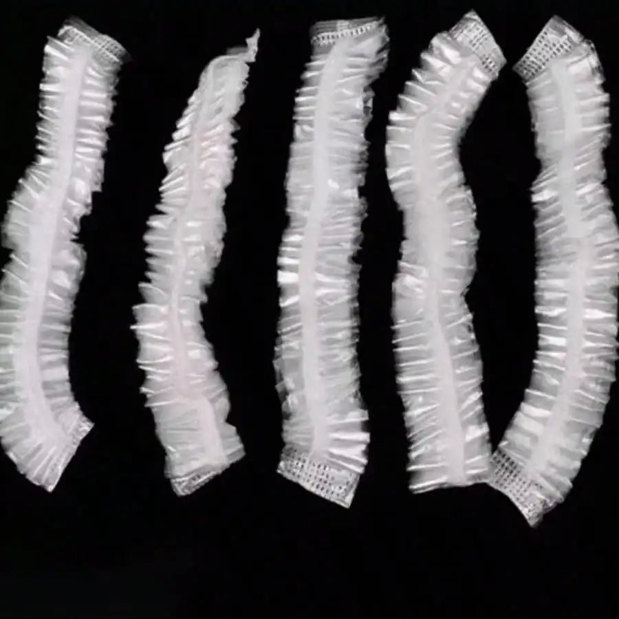 A set of disposable transparent shower caps arranged in a vertical line.