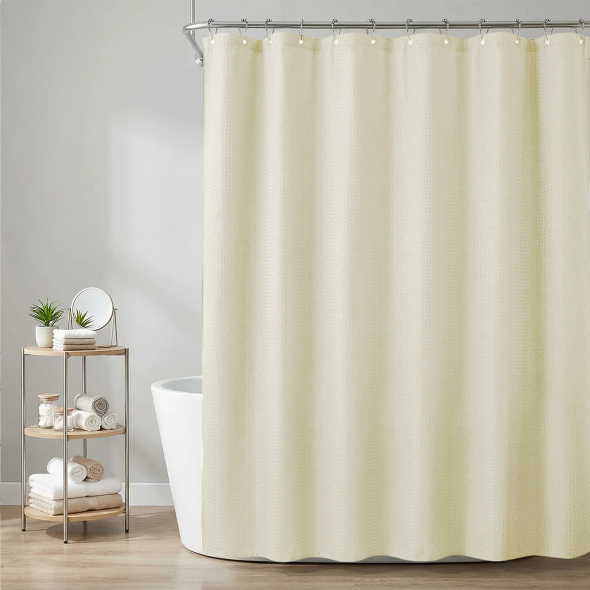 A cream-colored waffle weave shower curtain hanging from a metal rod in a bathroom setting.