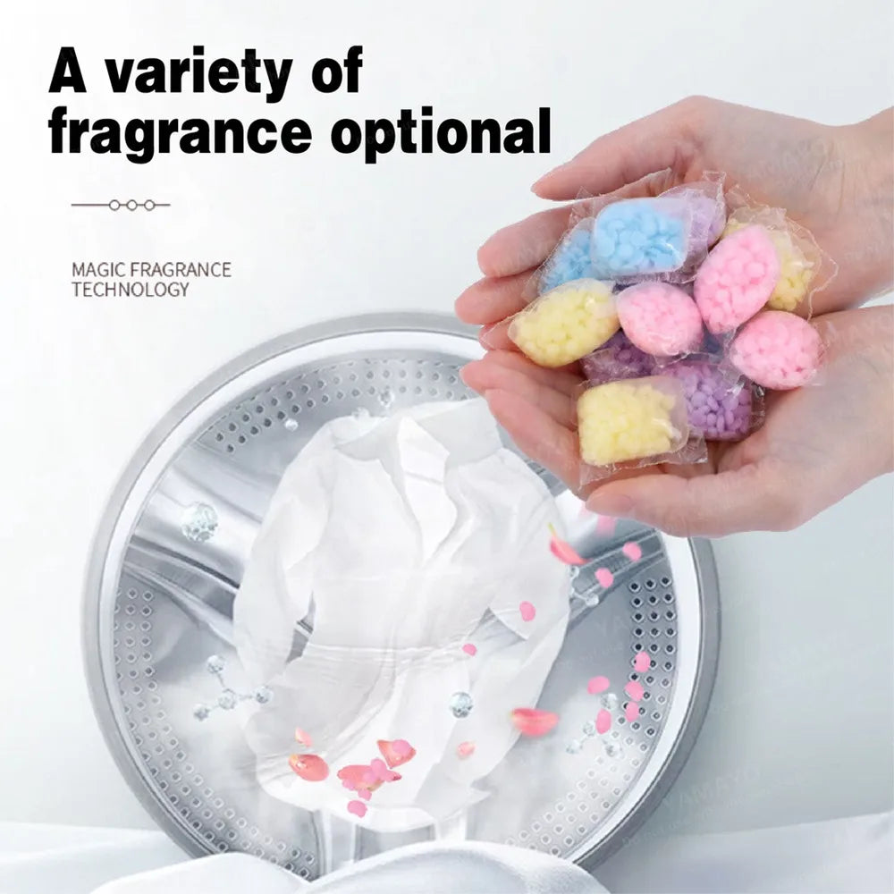 A hand holds a variety of colorful magic fragrance beads for laundry, displayed on a metal tray.