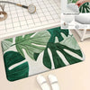 A green botanical leaf pattern printed on a white carpet mat with a soft silicone backing.