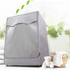 A silver Oxford washing machine cover with a roll edge is shown next to a stack of white towels and a woven basket.