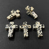 Three natural agate and jasper cross pendant charms on a dark background.