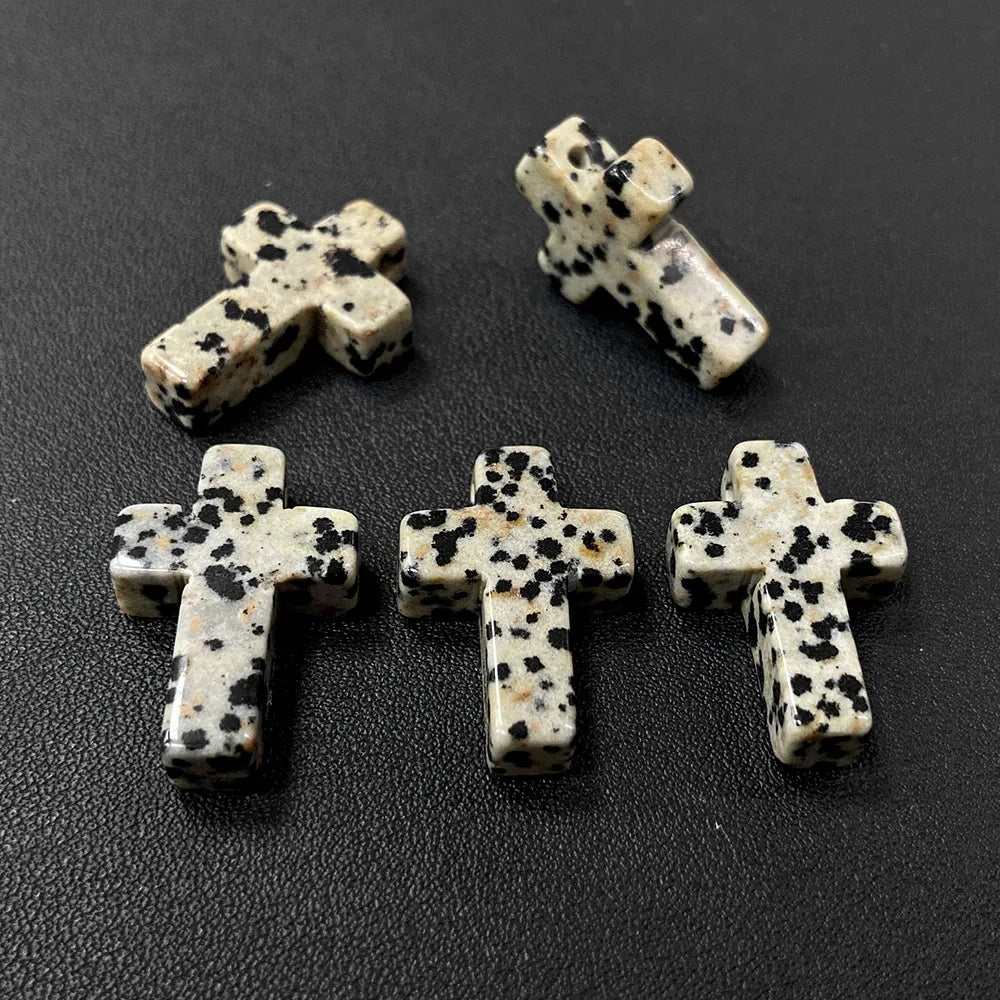 Three natural agate and jasper cross pendant charms on a dark background.