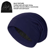 A navy blue satin sleep bonnet is shown, highlighting its smooth texture and luxurious feel.