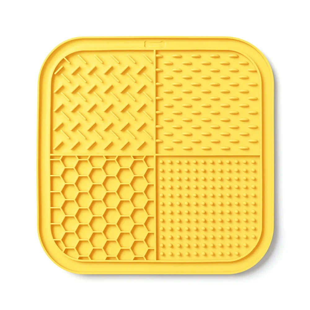 Yellow silicone lick mat divided into four sections for dogs and cats