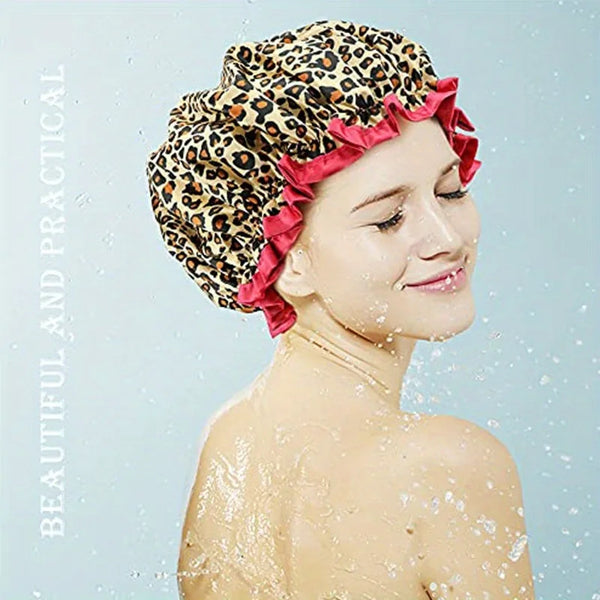 A woman wearing a leopard print double-layer shower cap with ruffled edges, wet and smiling.