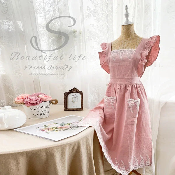 Rosa Leinen-Baumwoll-Schürzenkleid mit Rüschen und Spitzenborte auf einem Mannequin