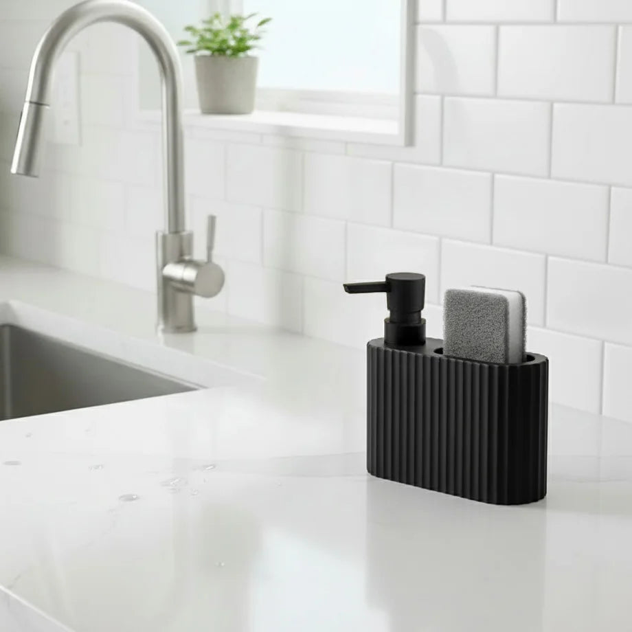 A black dish soap dispenser with a sponge holder sits on a white countertop next to a kitchen faucet.