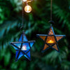 A blue glass star hanging candlestick with a warm light, suspended by a chain.