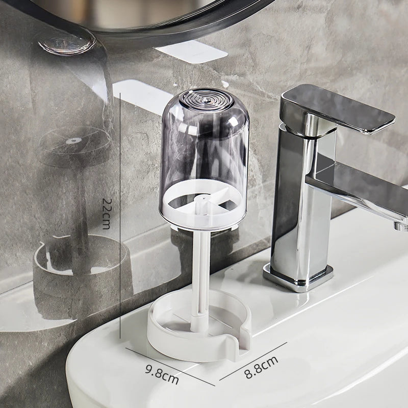 A chrome multi-compartment toothbrush holder with a drain is mounted on a white toilet tank.