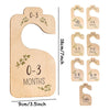 A set of wooden baby closet dividers showing age markers from 0-3 months to toddler