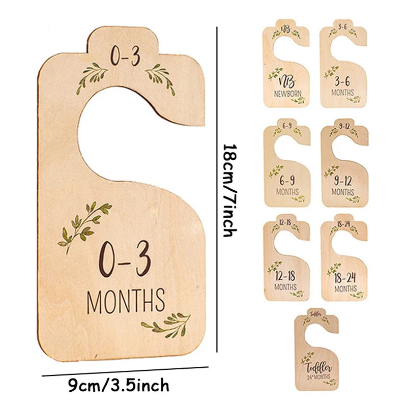 A set of wooden baby closet dividers showing age markers from 0-3 months to toddler