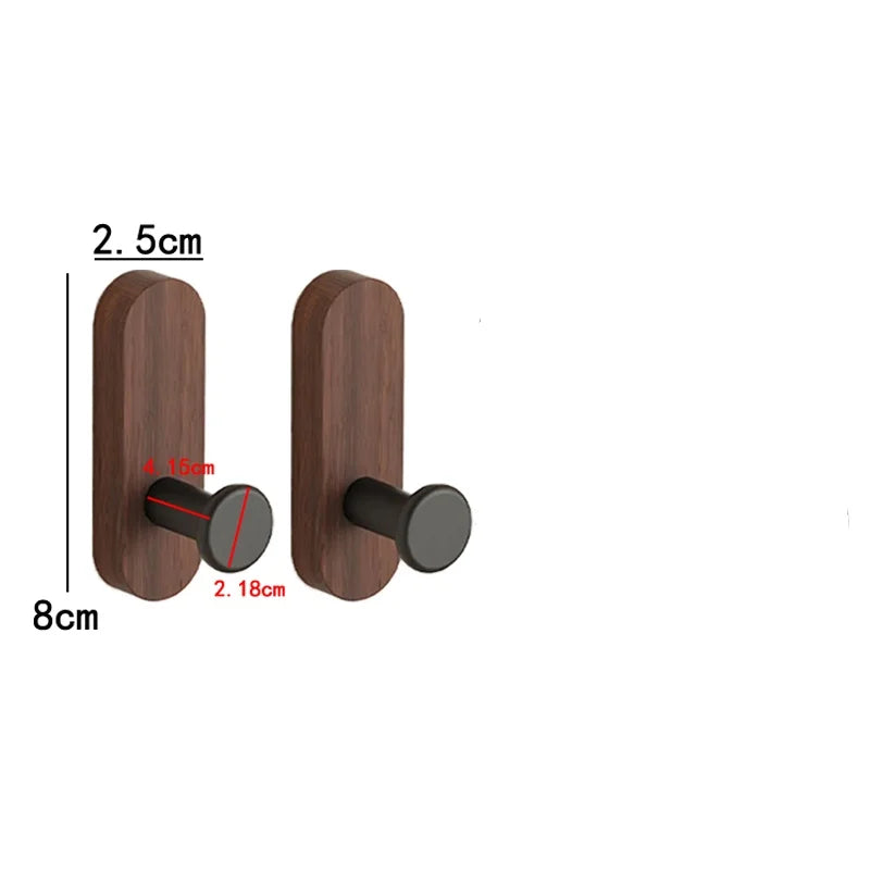 A pair of dark brown walnut wood wall hooks with round black mounting plates and self-adhesive features.