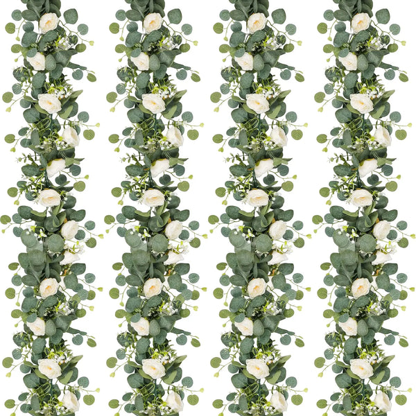 A vertical garland made of artificial eucalyptus leaves and white roses.