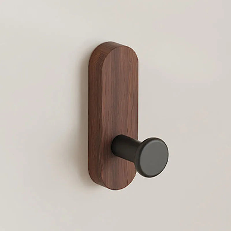 A dark brown walnut wood wall hook with a round black mounting piece.