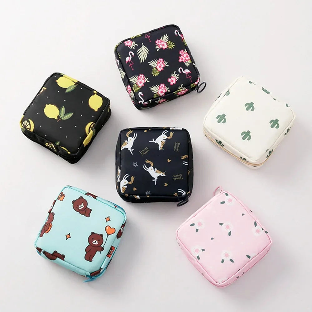A collection of various floral nylon sanitary pad storage pouches in black, pink, and light green.