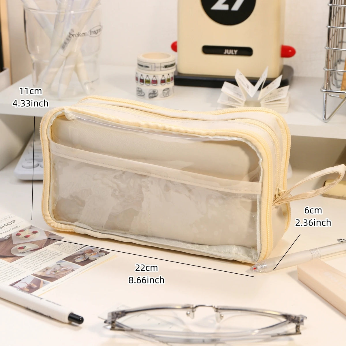 A beige transparent pencil pouch with a clear window showing pencils and other items.