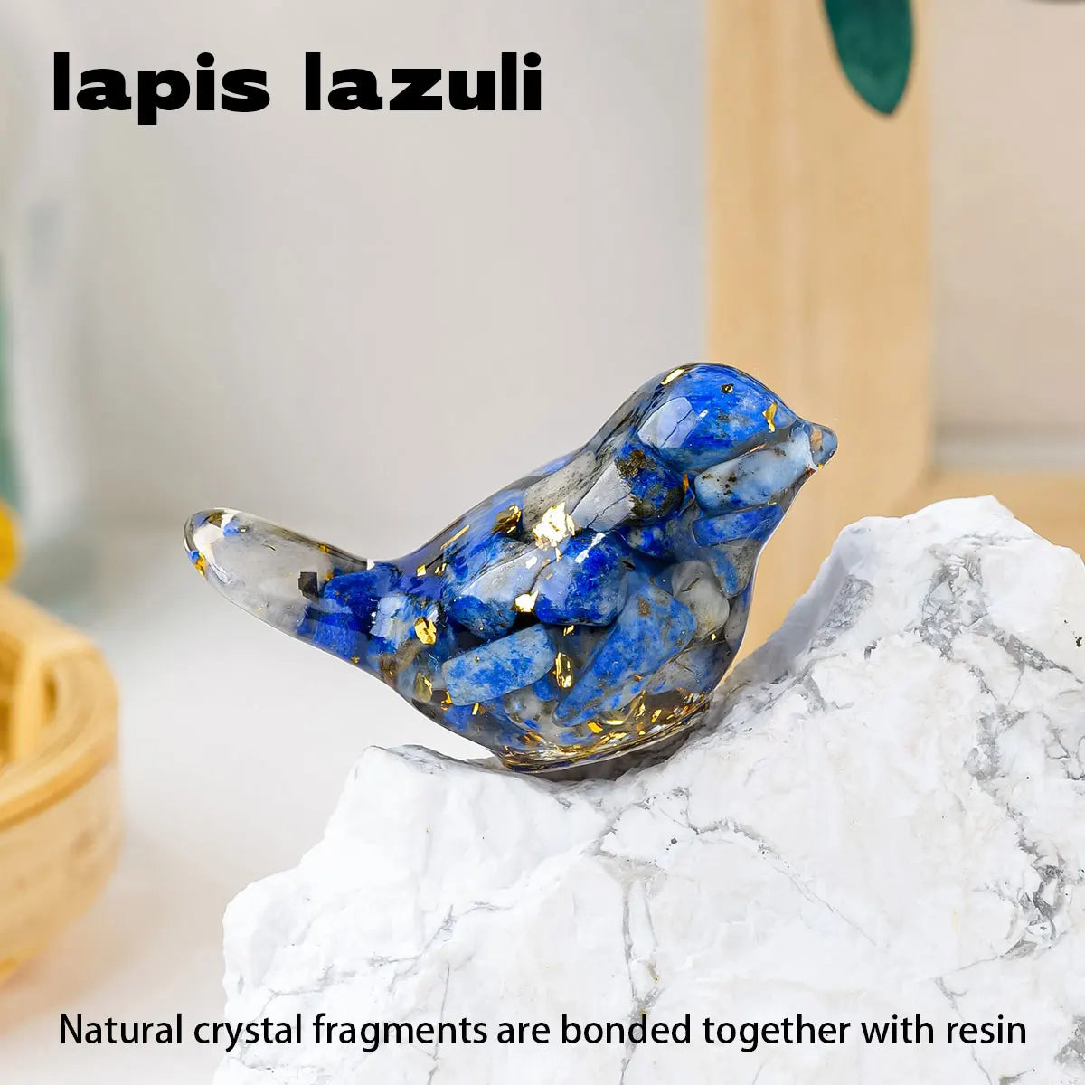 A blue lapis lazuli crystal bird statue made from natural crystal fragments bonded with resin, resting on a white stone.