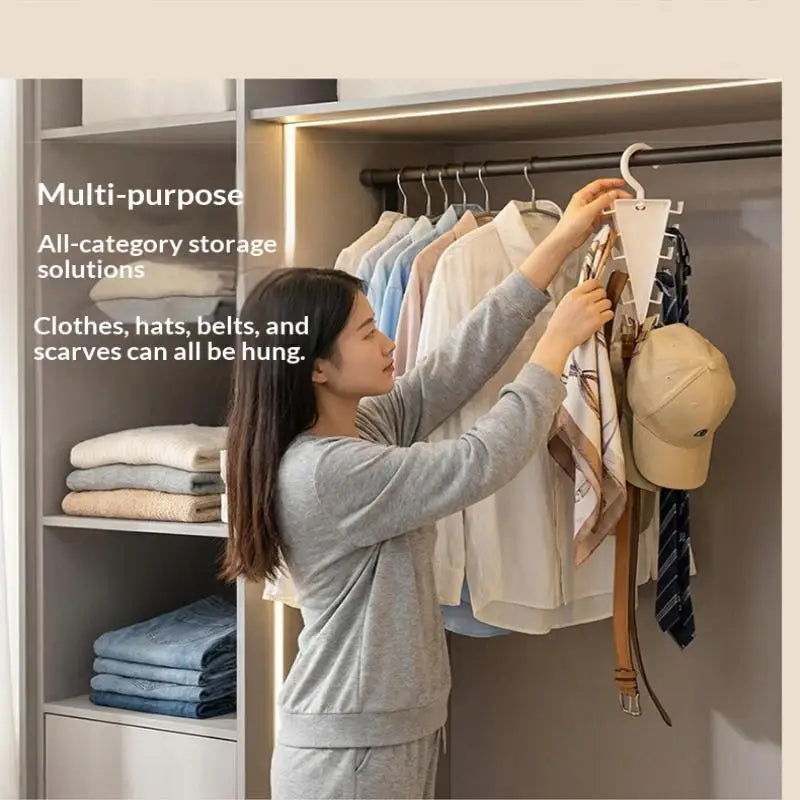 A woman hangs various items like clothes, hats, belts, and scarves on a multi-purpose closet organizer hanger.