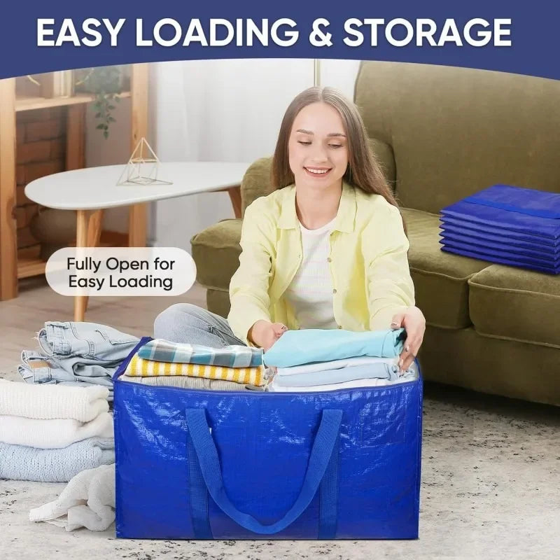 A young woman is shown easily loading a blue heavy duty moving bag with handles full of folded clothes onto a sofa.