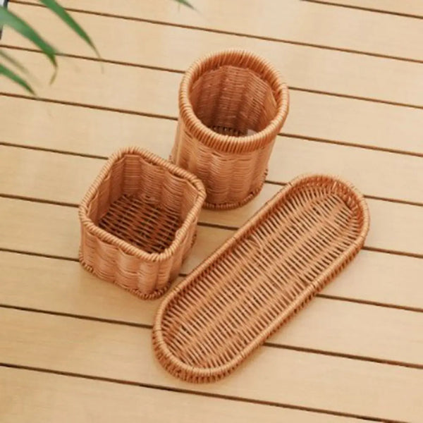 Three handwoven rattan serving baskets in natural tan color resting on a light wooden surface.
