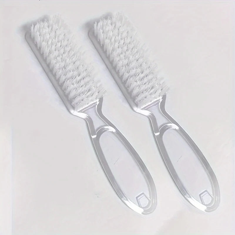 A pair of clear plastic brushes with white bristles for nail art and dust cleaning.