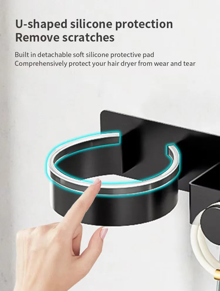 Une main place un coussin de protection en silicone en forme de U sur un support de séche-cheveux fixé au mur noir.