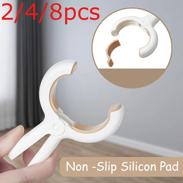 A hand holds a white non-slip silicone drying clip, showing the clamp and the individual pieces.