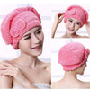 A woman is shown wearing a pink microfiber hair drying towel cap on her head.