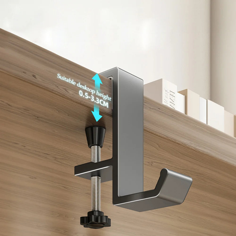 A silver aluminum desk hanging hook is mounted on a wooden surface, showing its suitable desktop height of 0.5 to 3.3 cm.