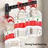 Three clear plastic water bottles are hanging from a black wall-mounted rack.