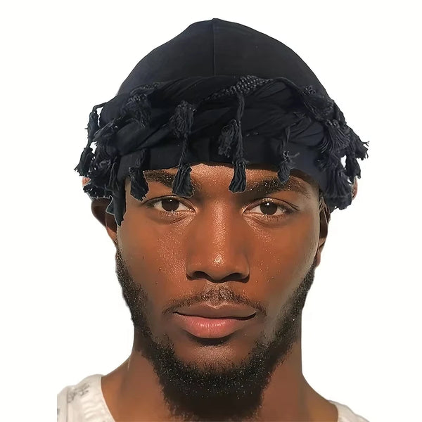 A close-up portrait of a man wearing a black vintage twist head wrap durag with tassels.