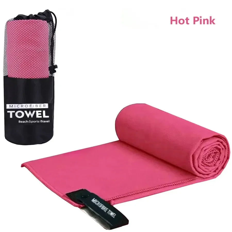 Hot pink microfiber towel rolled up and a folded towel displayed on a white background.