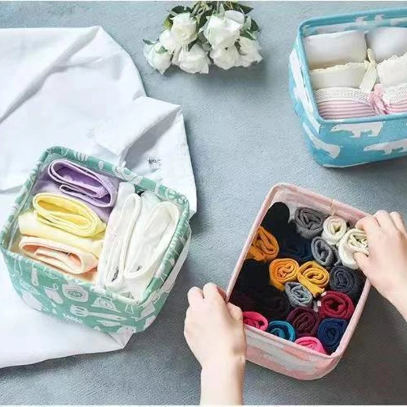 A collection of folded white, purple, and yellow fabric items stored in various storage baskets.