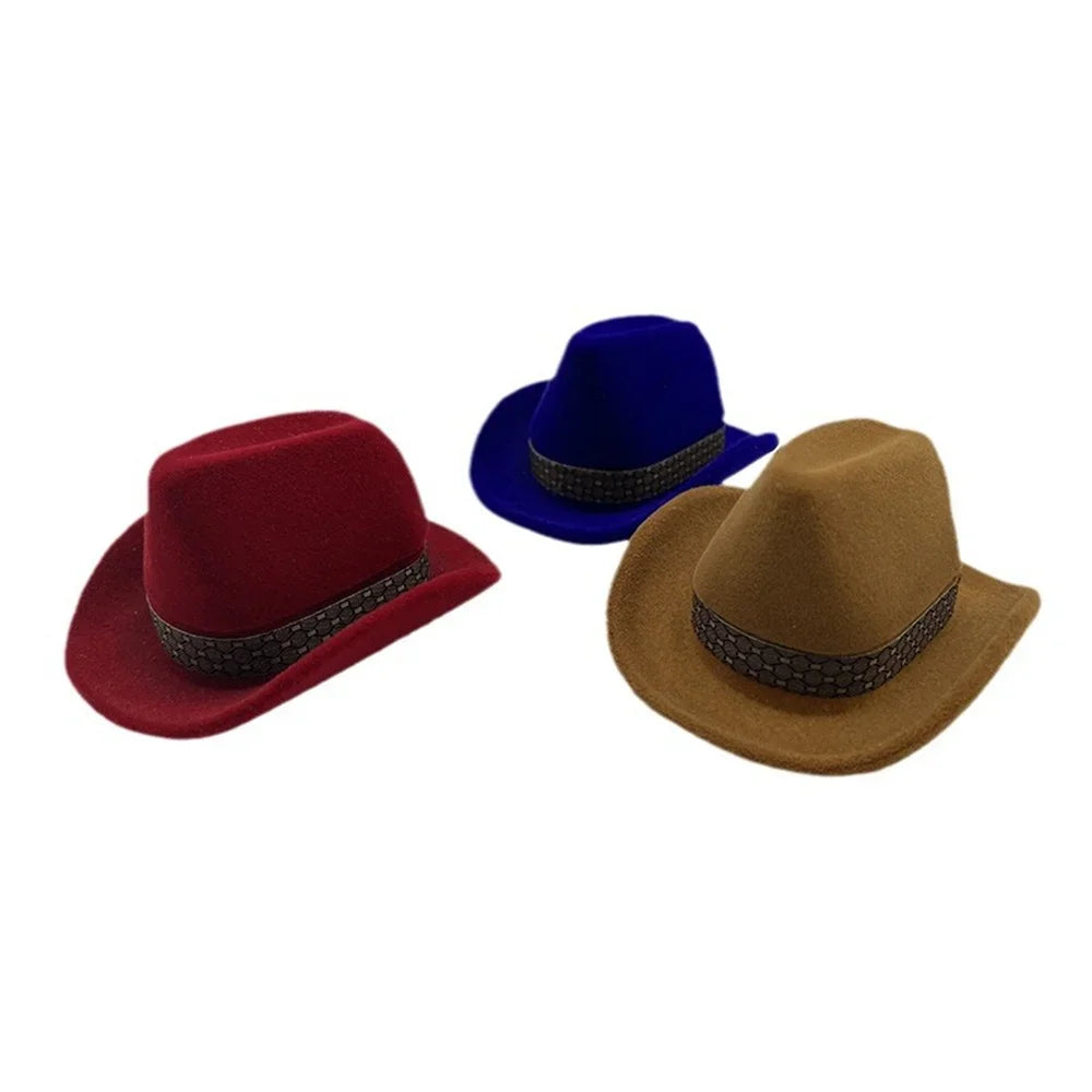 Three velvet cowboy hats in red, blue, and tan displayed together.