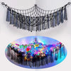 A black bohemian stuffed animal hammock featuring dangling fabric and colorful plush toys.