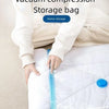 A person is using a hand pump to compress a storage bag for clothing or bedding.
