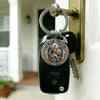A black keychain featuring a silver medallion of Saint Michael the Archangel, attached to a brass door hook.