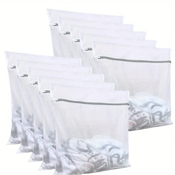 A stack of clear mesh laundry bags with zippers, filled with white towels or clothing.