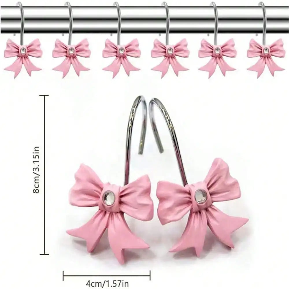 A set of twelve pink decorative bow tie shower curtain hooks hanging from a metal bar.