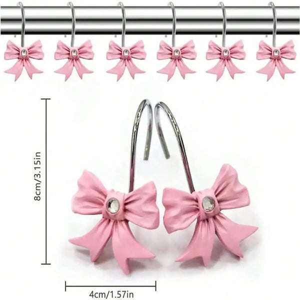 A set of twelve pink decorative bow tie shower curtain hooks hanging from a metal bar.