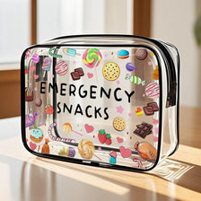 A clear plastic travel organizer pouch filled with colorful emergency snacks like lollipops and candies.