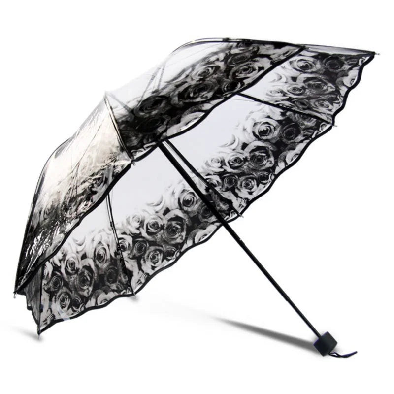 A black retro transparent folding umbrella with a floral pattern is shown open.