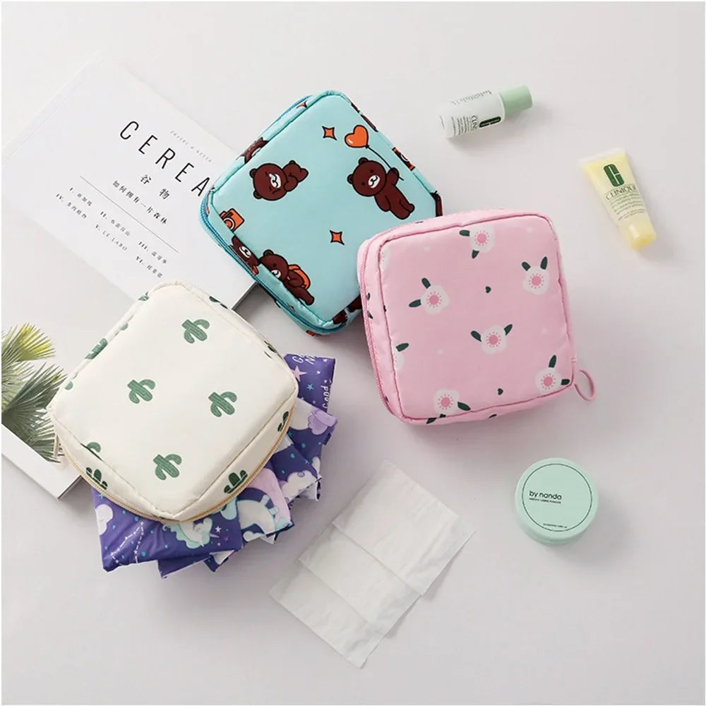 A pink floral nylon sanitary pad storage pouch next to a white pouch and some skincare products.
