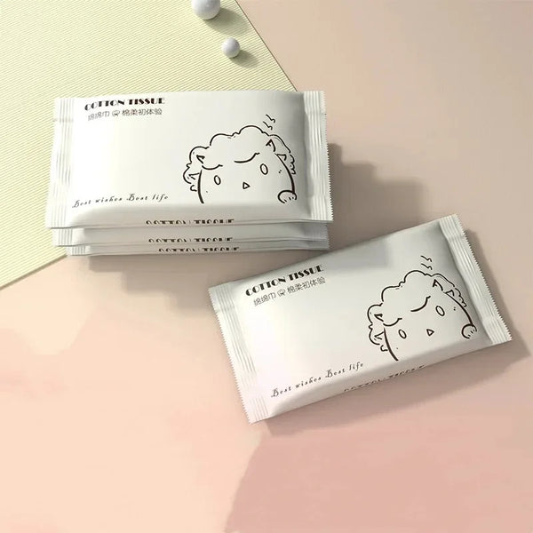 A stack of cotton tissue facial cleansing wipes is displayed on a light pink surface.